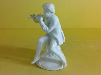 A Bow small figure of a seated flautist 