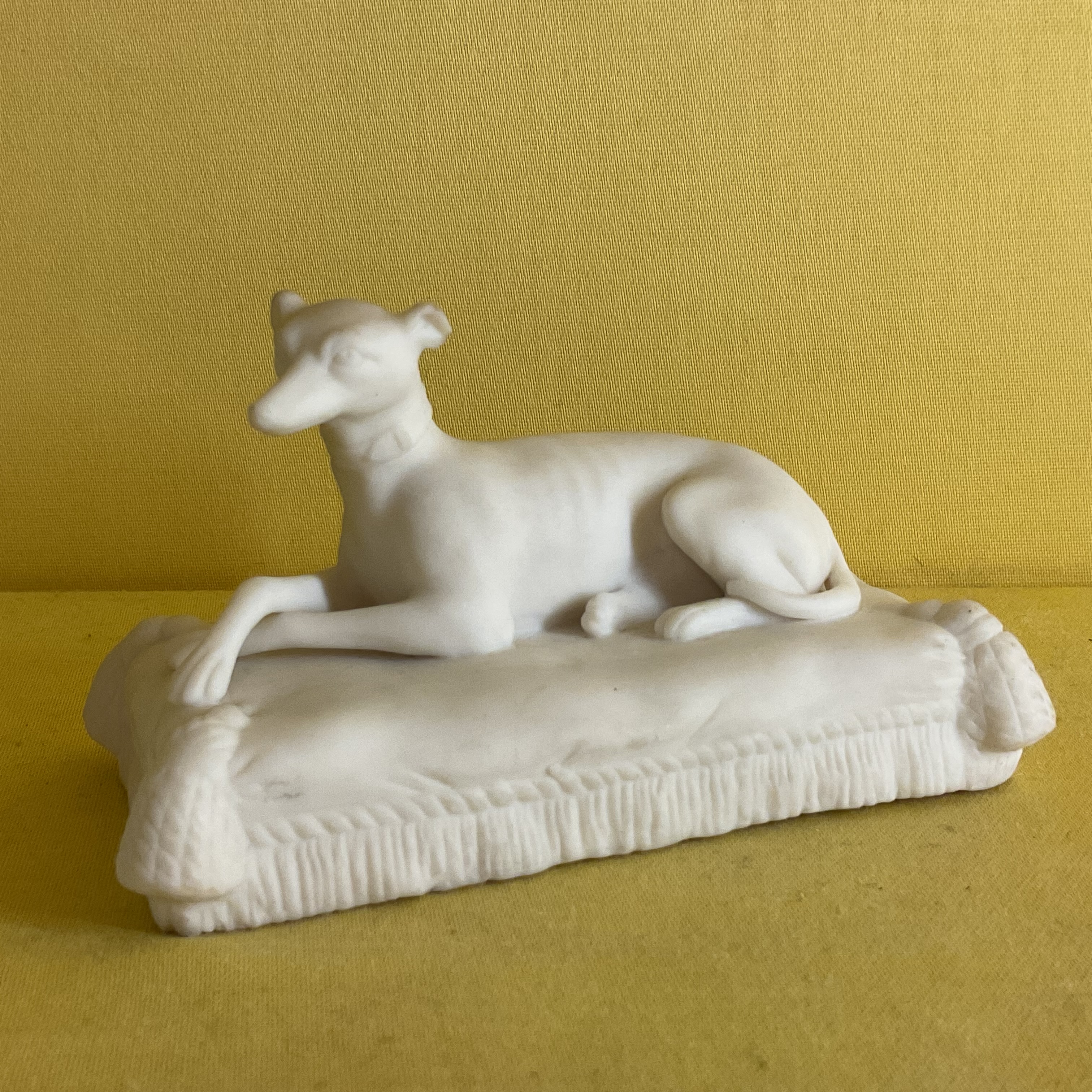 A Minton biscuit porcelain model of a greyhound 